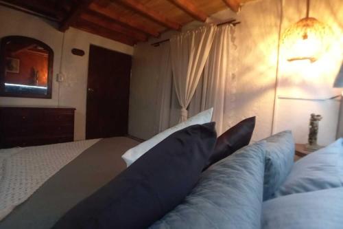 a bedroom with a bed with blue pillows at Boresta House -Santa Elena con vista al Bosque y terraza privada in Medellín