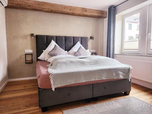 a bedroom with a large bed with white sheets and pillows at Boutique Hotel Marielle in Bad Münstereifel