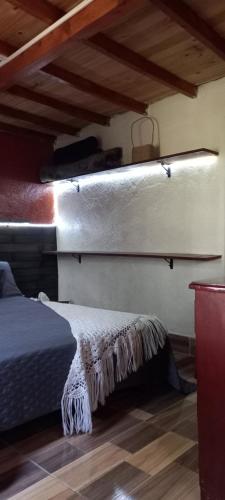 a bed in a room with appelin at Boresta House -Santa Elena con vista al Bosque y terraza privada in Medellín