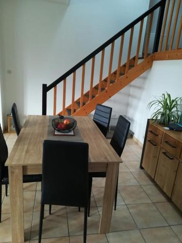- une table en bois avec des chaises et une corbeille de fruits dans l'établissement Grand Duplex T3 proche La Rochelle, à Salles-sur-Mer