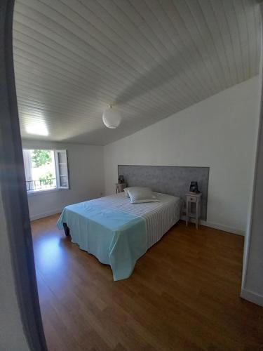 une chambre avec un lit dans une pièce blanche dans l'établissement Grand Duplex T3 proche La Rochelle, à Salles-sur-Mer