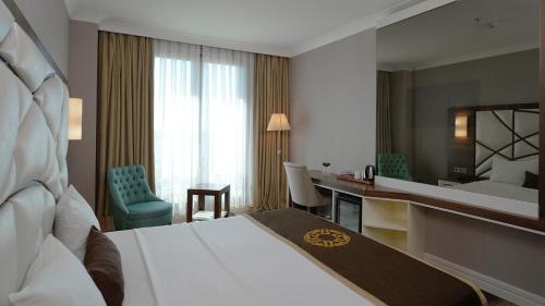 a hotel room with a bed and a desk at The Grand Mira Business Hotel in Istanbul