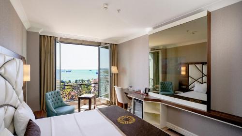 a hotel room with a bed and a desk and a mirror at The Grand Mira Business Hotel in Istanbul
