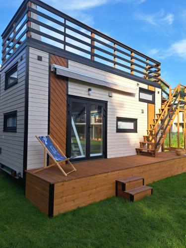 a tiny house with a deck and a staircase at Dworek MARINO KOŁOBRZEG in Grzybowo