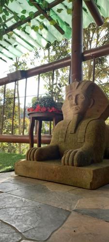 a statue of a person sitting next to a table at Boresta House -Santa Elena con vista al Bosque y terraza privada in Medellín