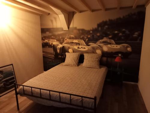a bedroom with a bed with cars on the wall at Le Vintage Loft Garage in Saint-Agnan-sur-Loire