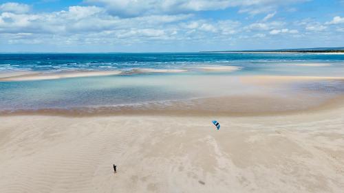 a person standing on a beach with a kite at Morrumbene Beach Resort in Morrumbene