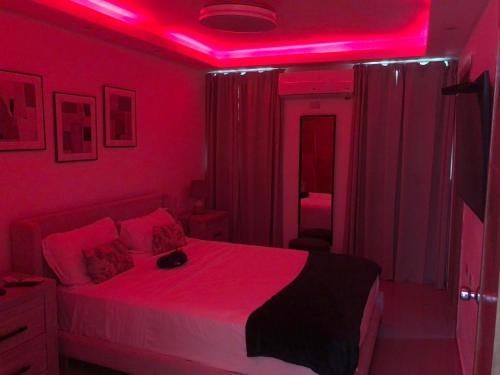 a bedroom with a bed with a pink lighting at Lo mejor para descansar in Mendoza