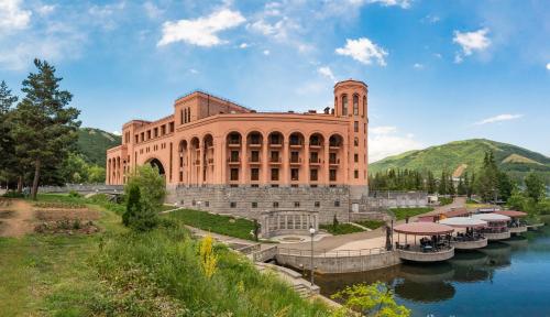 ジェルムクにあるGrand Resort Jermukの水の横の大きなレンガ造りの建物