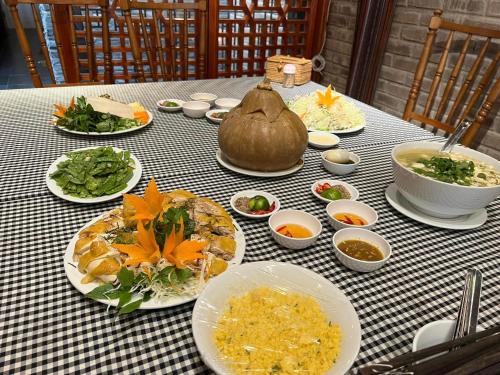 a table with plates of food on a checked table cloth at Ethnic House Jr in Dồng Văn