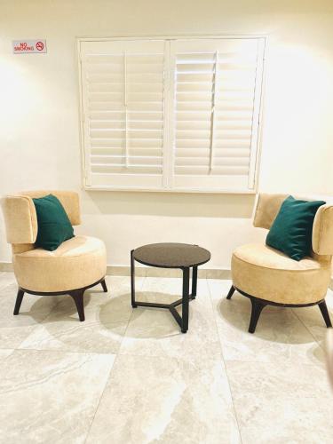 two chairs and a table in a room at Tranquil Oasis Hotel in Ilado
