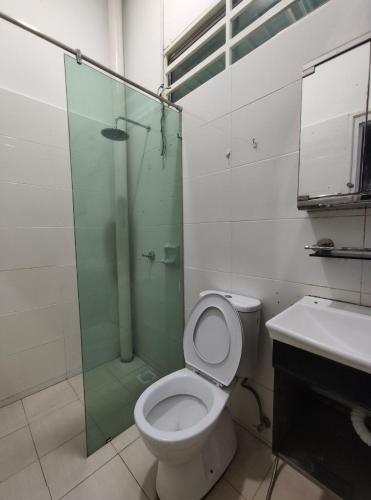 a bathroom with a shower and a toilet and a sink at Maileyna Homestay 2 in Kampong Alor Merah