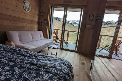 une chambre avec un lit, un canapé et une fenêtre dans l'établissement Appartement ludothèque familial neuf à Combloux, à Combloux