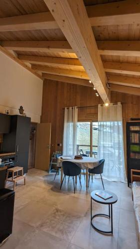 un grand salon avec une table et des chaises dans l'établissement Appartement ludothèque familial neuf à Combloux, à Combloux