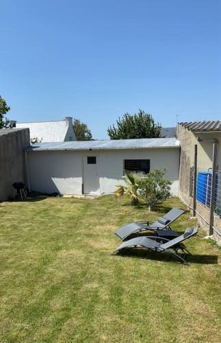 a yard with two chairs and a house at Vitamine Sea in Ploemeur