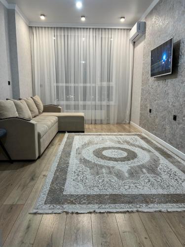 a living room with a couch and a rug at Культегин 14 in Taldykolʼ