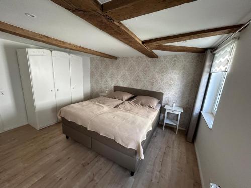 a bedroom with a bed and a wooden floor at Ferienwohnung Wesertraum in Lauenförde