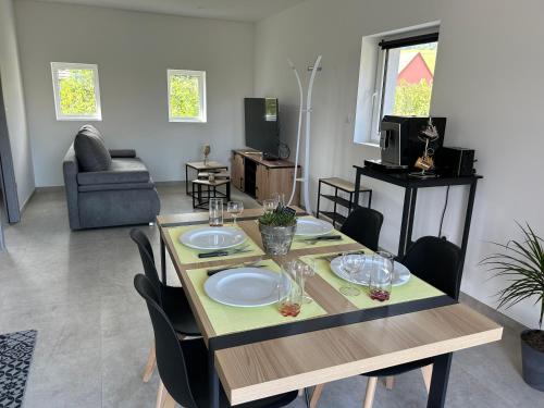 - une salle à manger avec une table et des assiettes dans l'établissement Gîte neuf en duplex tout confort, à Ribeauvillé