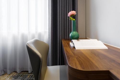 a desk with a vase with a flower on it at Fortune Land Shenzhen in Shenzhen