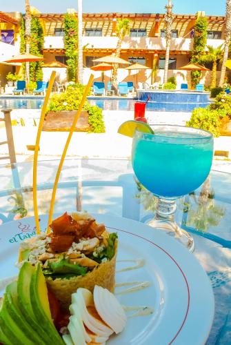 a plate of food on a table with a drink at Hotel Los Patios in Cabo San Lucas