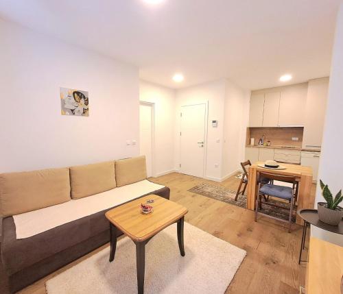 una sala de estar con un sofá y una mesa en Pine Forest Magic, en Bjelašnica