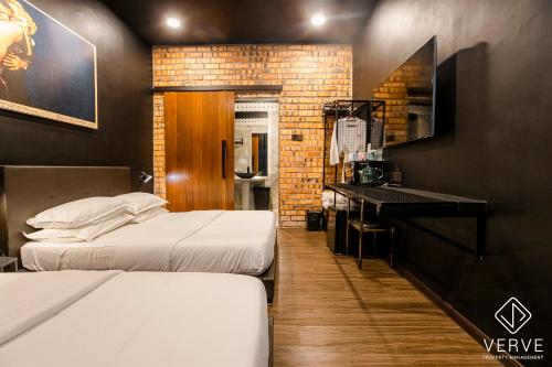 a hotel room with two beds and a desk at Ipoh The Label by Verve in Kampong Simee