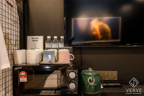 a kitchen with a microwave and a tv on a counter at Ipoh The Label by Verve in Kampong Simee