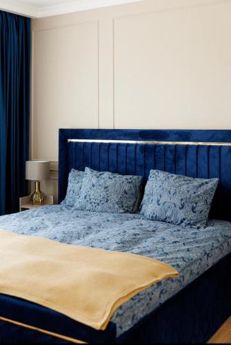 a blue bed with blue sheets and pillows at Smarald Luxury Apartment in Satu Mare
