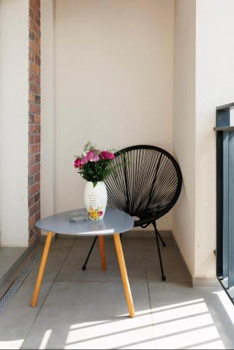 a vase of flowers sitting on a table next to a bench at Smarald Luxury Apartment in Satu Mare