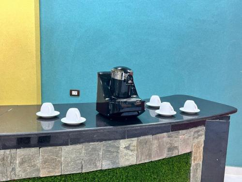 a coffee maker on a table with white hats on it at Reef House in Marsa Alam City