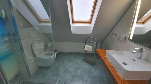 a bathroom with a sink and a toilet and a window at Hotel/Restaurant Balkan in Sömmerda