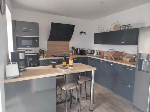 une cuisine avec un comptoir en bois dans une pièce dans l'établissement Longère 5 mn de l'océan avec piscine privée, à Plouhinec