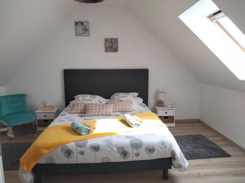 une chambre avec un grand lit dans un grenier dans l'établissement Longère 5 mn de l'océan avec piscine privée, à Plouhinec