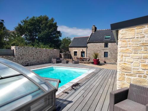 une maison avec une piscine dans une cour dans l'établissement Longère 5 mn de l'océan avec piscine privée, à Plouhinec