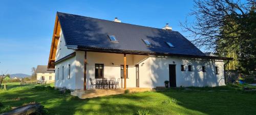 a small white house with a black roof at HabaChalupa in Šumperk