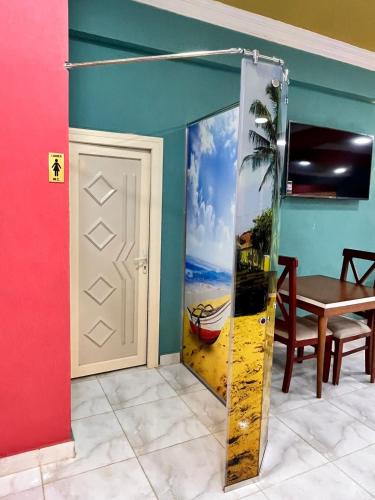 a door in a room with a painting of a boat at Reef House in Marsa Alam City