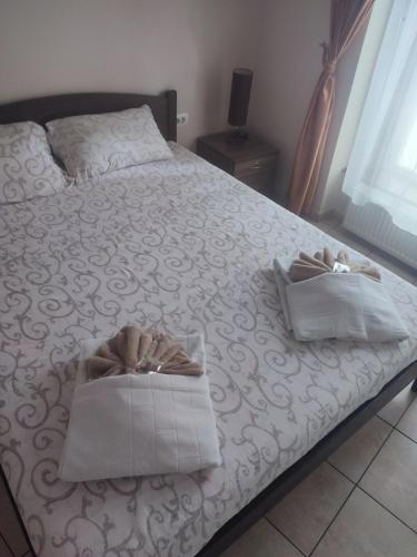 a bedroom with a bed with two towels on it at Guest House Best Food in Subotica