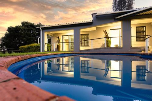 a house with a swimming pool in front of it at 8 On Eagle Bed & Breakfast Room 1 in Umtentweni