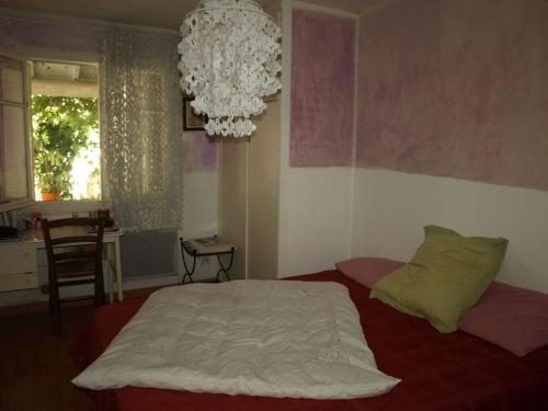 une chambre avec un lit et un lustre dans l'établissement Maison centre Montpellier Jardin et proche plage, à Montpellier