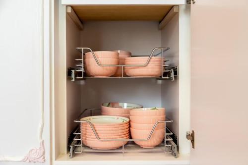 a cupboard filled with pink pots and pans at 春漫小築民宿 in Miaoli
