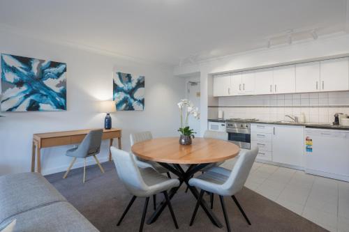 a kitchen and dining room with a wooden table and chairs at Mounts Bay Stay 2 Bedroom Apt - Near Kings Park - Free Parking in Perth