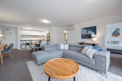 a living room with a couch and a table at Mounts Bay Stay 2 Bedroom Apt - Near Kings Park - Free Parking in Perth