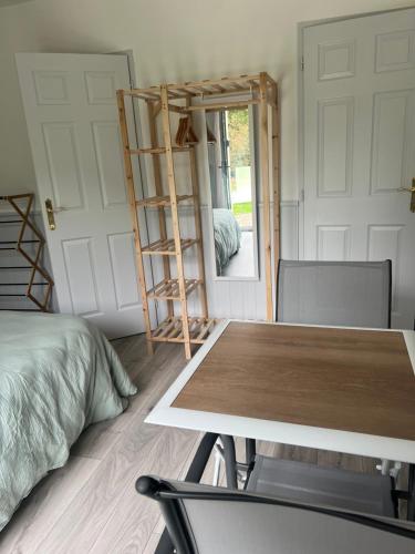 a room with a table and a ladder and a bed at Un peu de campagne in Saint-Gilles-de-la-Neuville