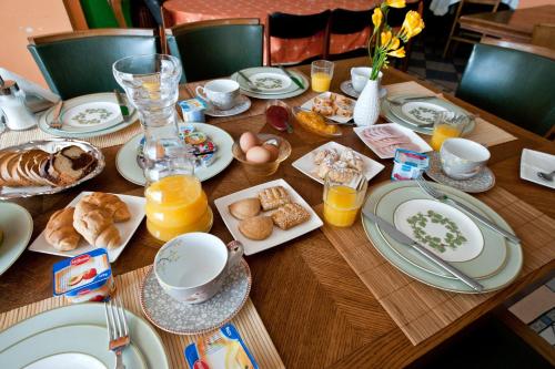 a wooden table topped with plates of food and orange juice at Akti in Nafpaktos