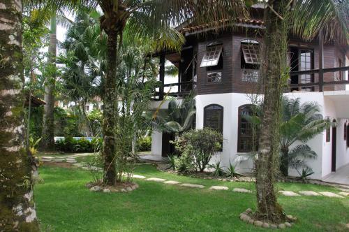 a house with palm trees in front of it at Pousada Chalé Suíço in Paraty