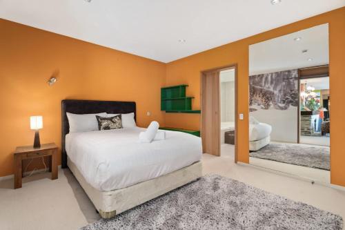 a bedroom with a large bed and a mirror at Mt Alta views Central Wanaka in Wanaka