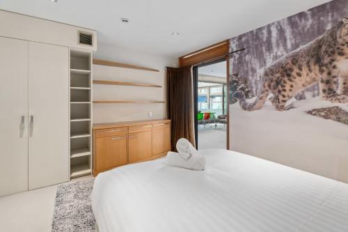 a bedroom with two beds and a wall with a cheetah mural at Mt Alta views Central Wanaka in Wanaka