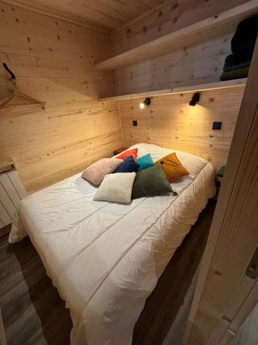 a bed in a wooden room with pillows on it at Les appartements de Makalu Val Thorens in Val Thorens