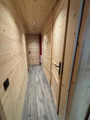 a hallway in a wooden cabin with wooden floors and doors at Les appartements de Makalu Val Thorens in Val Thorens