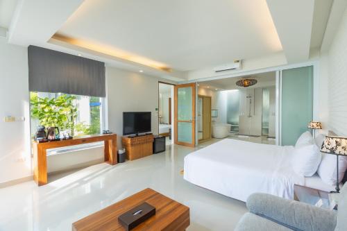 a bedroom with a bed and a living room at KC Beach Club & Pool Villas in Chaweng